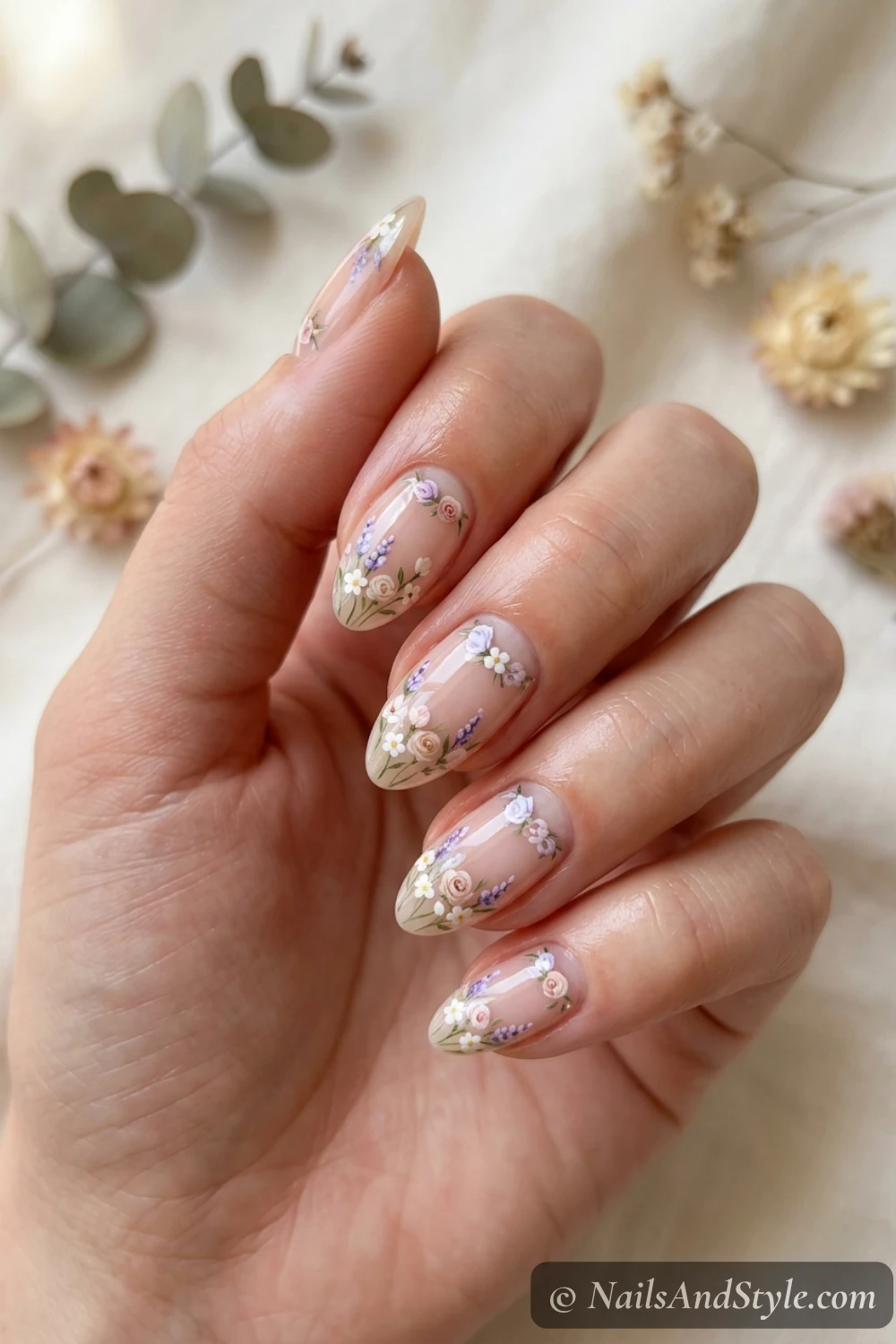 Sheer nails with a tiny painted floral cluster in the half-moon