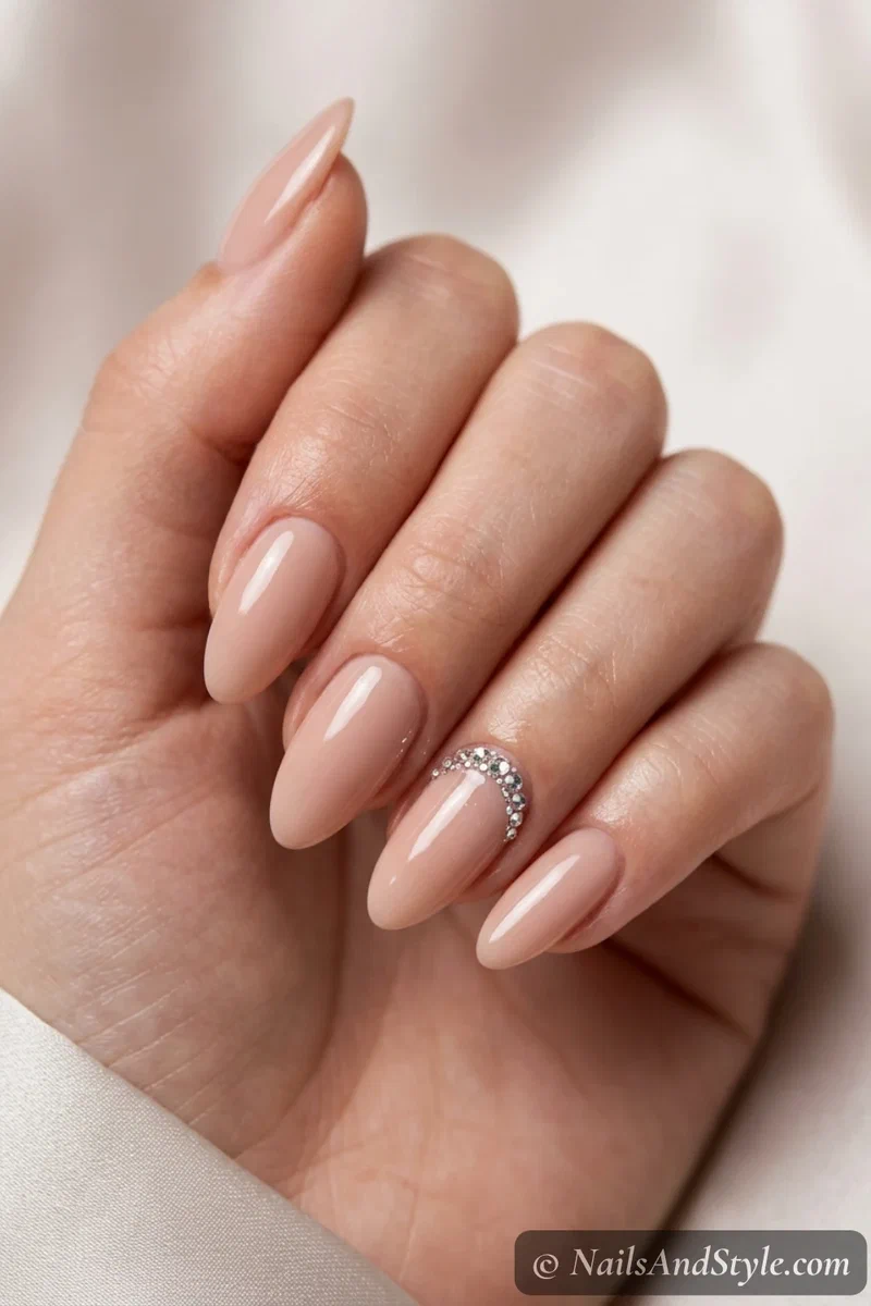 Nude nails with rhinestone half-moon