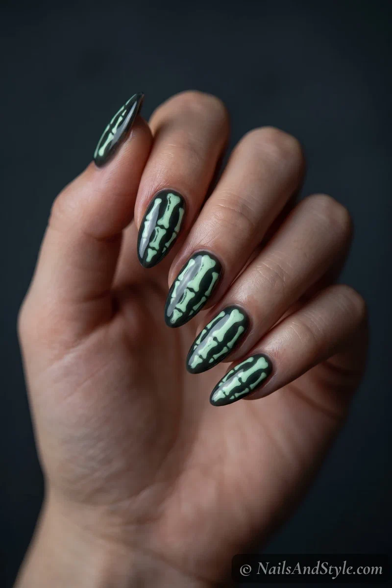 Dark nails with skeleton bones glowing pale green in low light