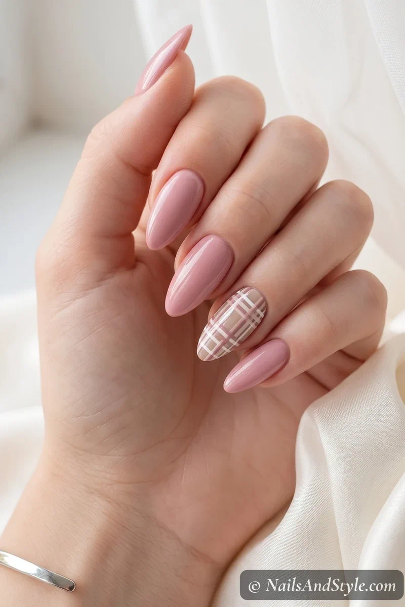 Neutral nails with one plaid accent nail in beige and pink tones