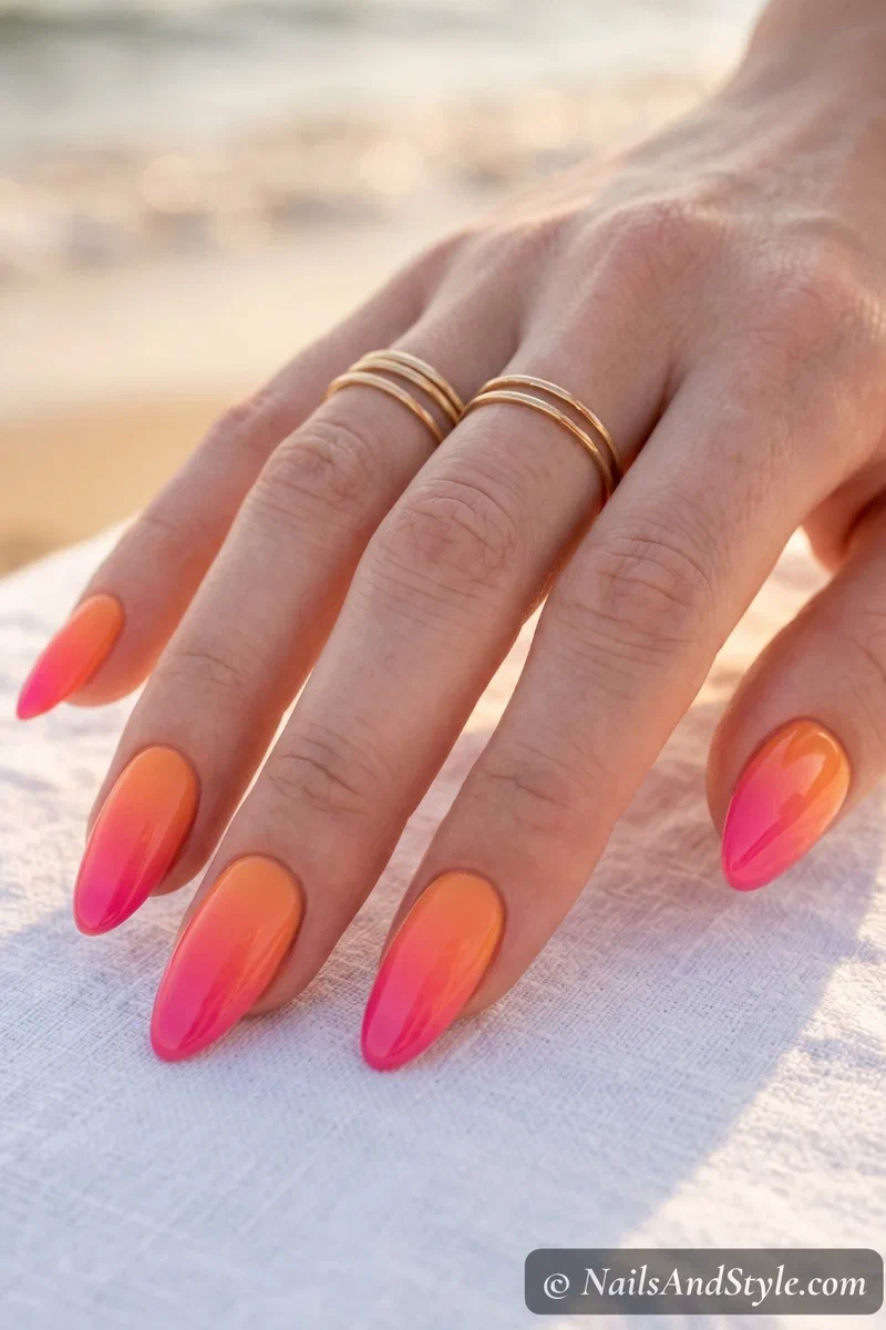 Classic sunset ombre nails blending orange to coral to pink on medium almond nails