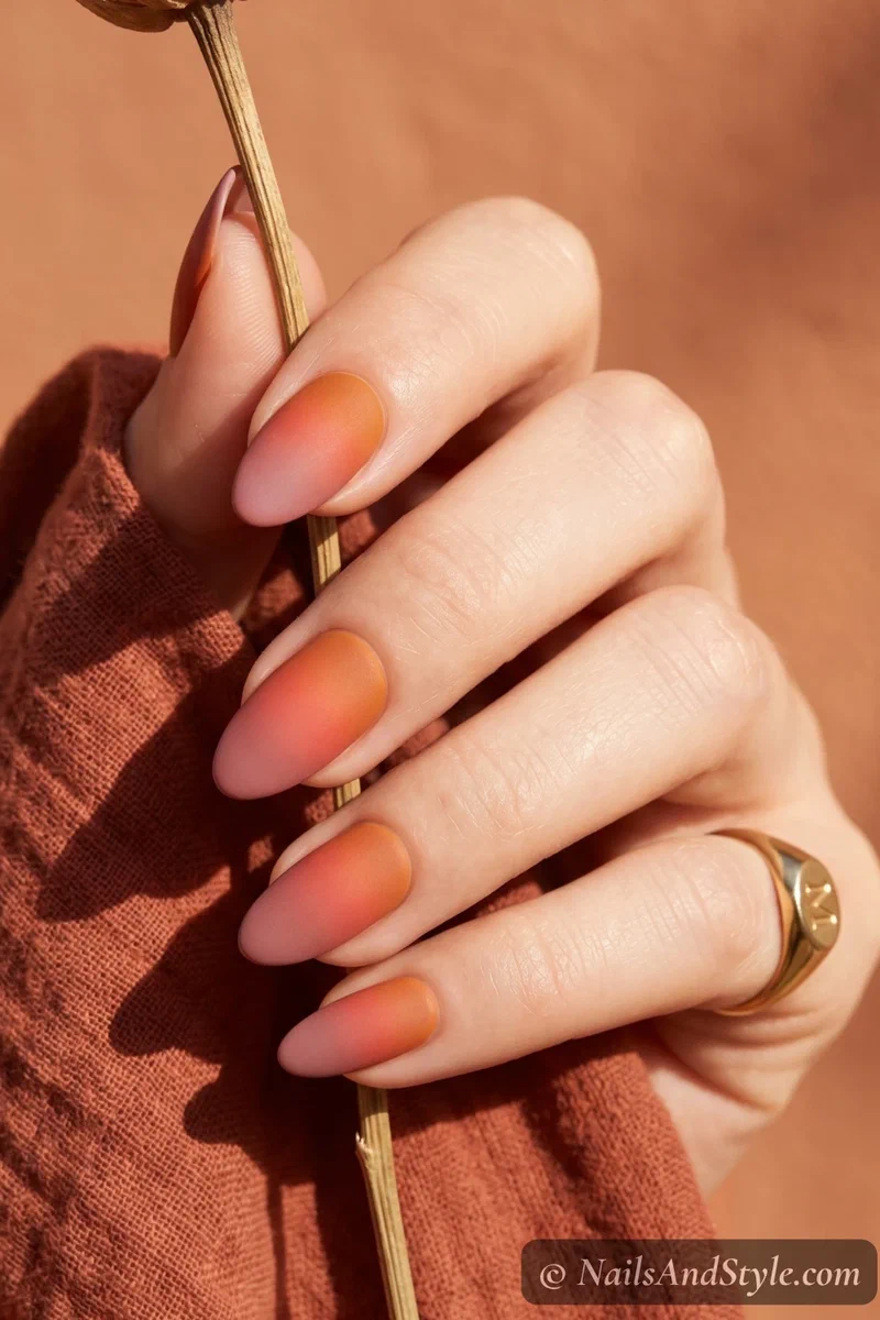 Matte finish sunset gradient nails in orange to pink on medium nails