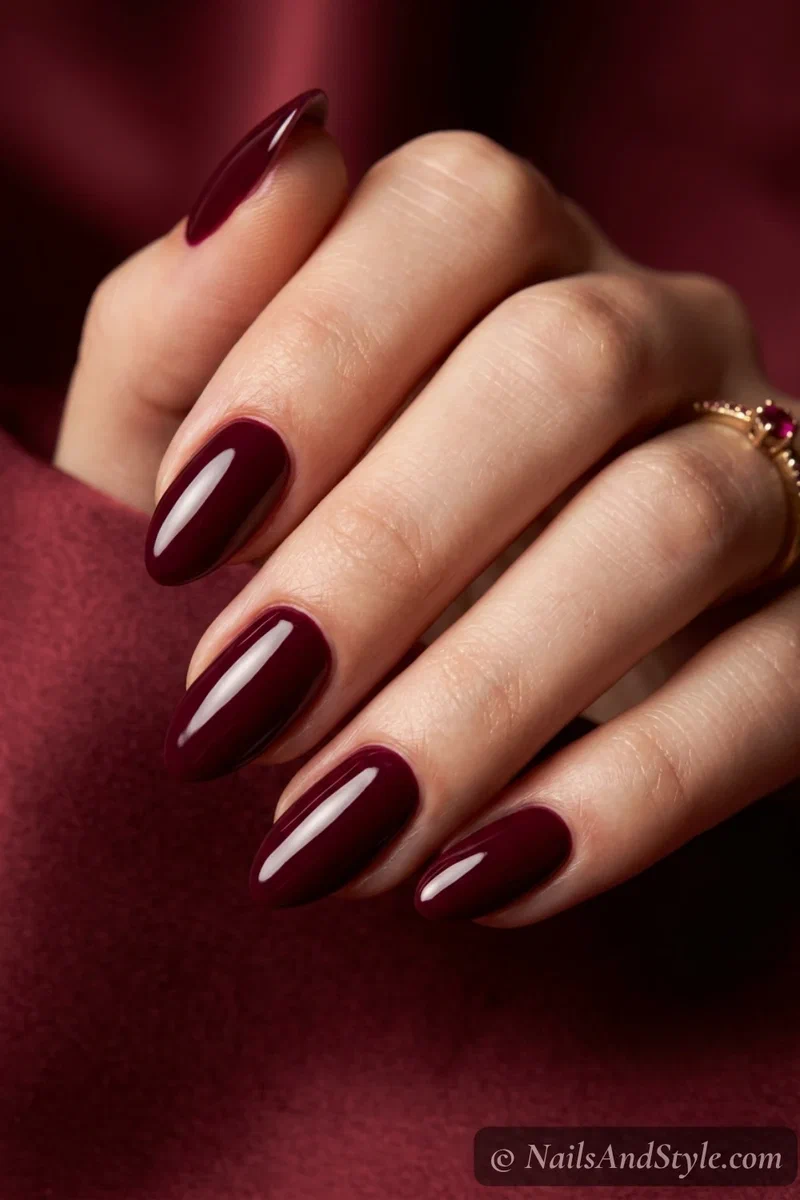 Burgundy nails with a deep rich wine red and glossy finish on medium almond nails