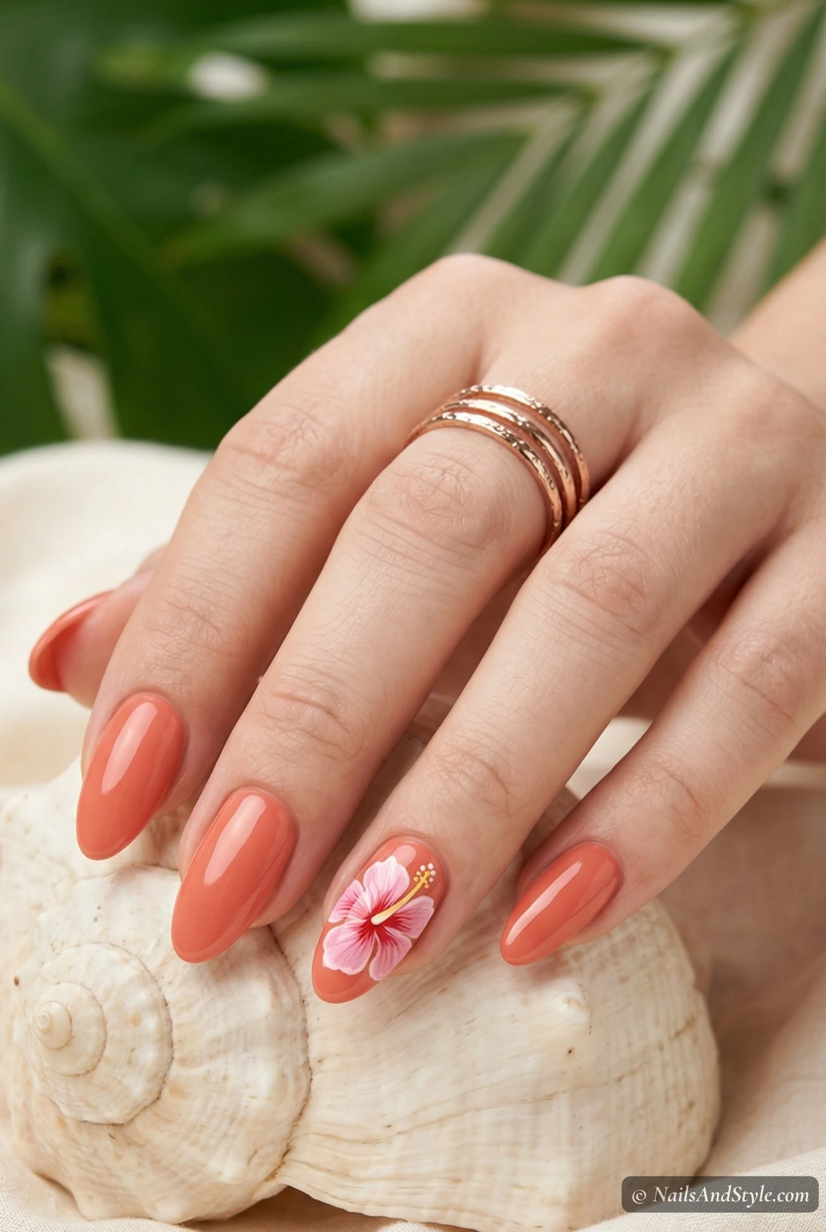 Coral nails with a hibiscus accent