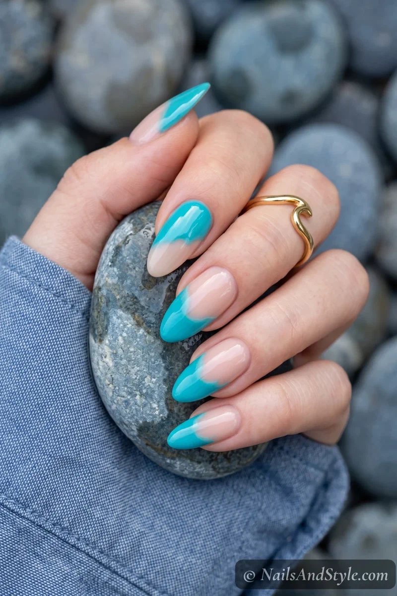 Half-painted nails with turquoise dip-dye effect on upper portion and bare base