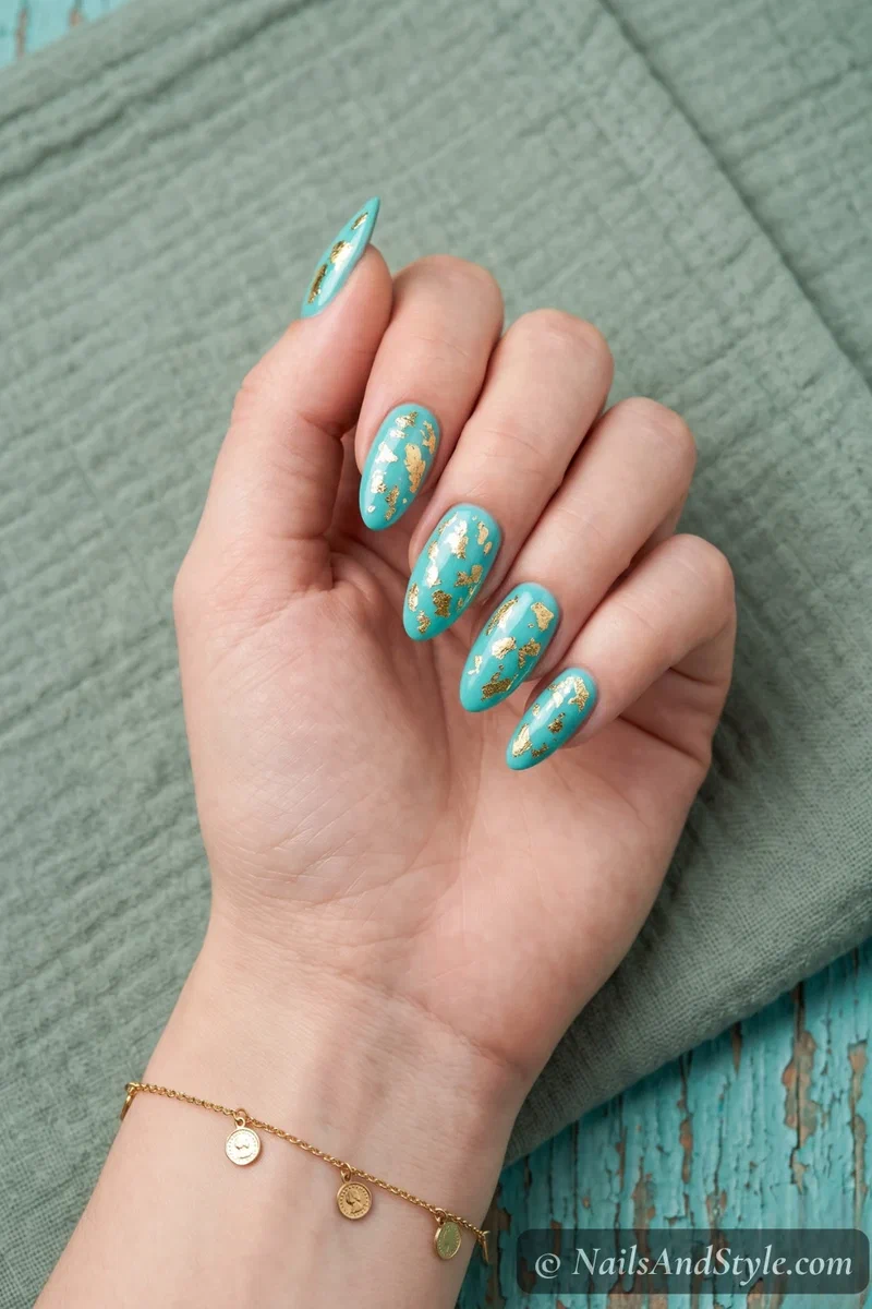 Turquoise nails with irregular gold foil pieces pressed onto the surface
