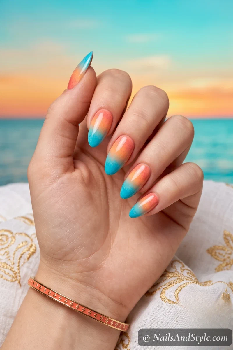 Gradient nails blending warm coral at cuticle to turquoise at tips