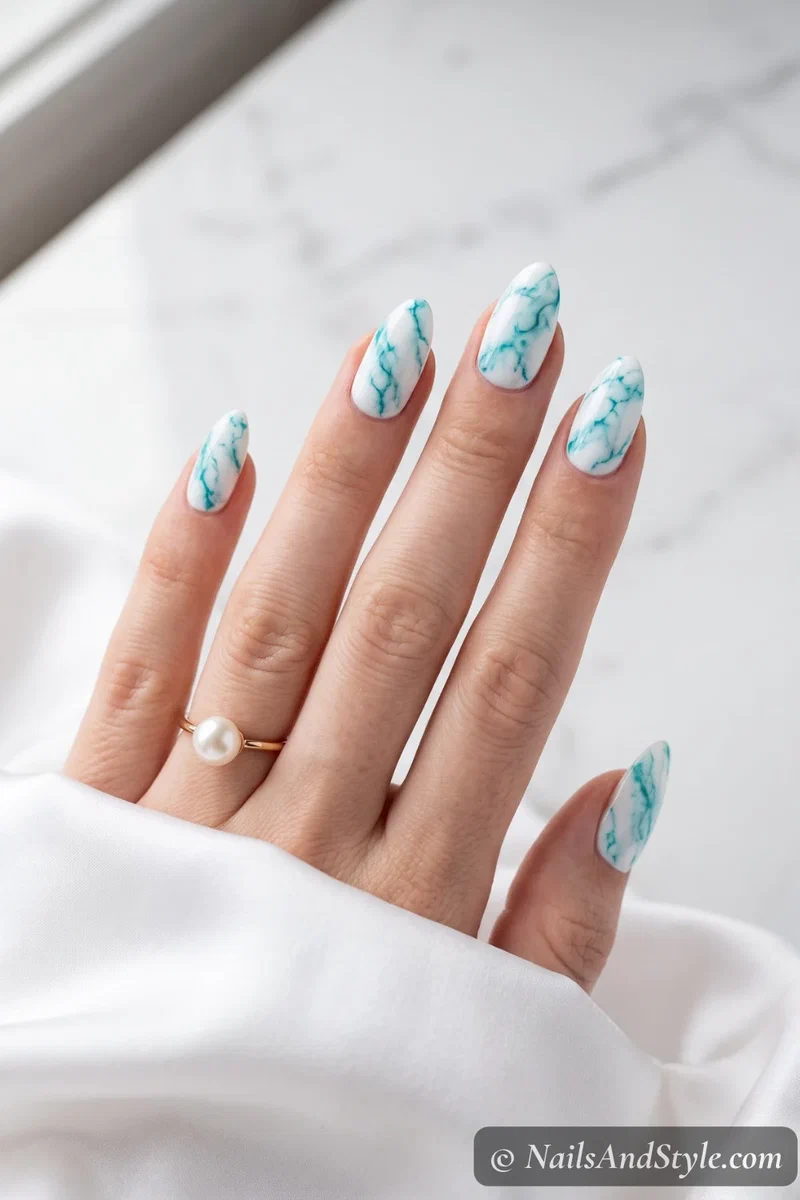 White base nails with turquoise marble veining pattern