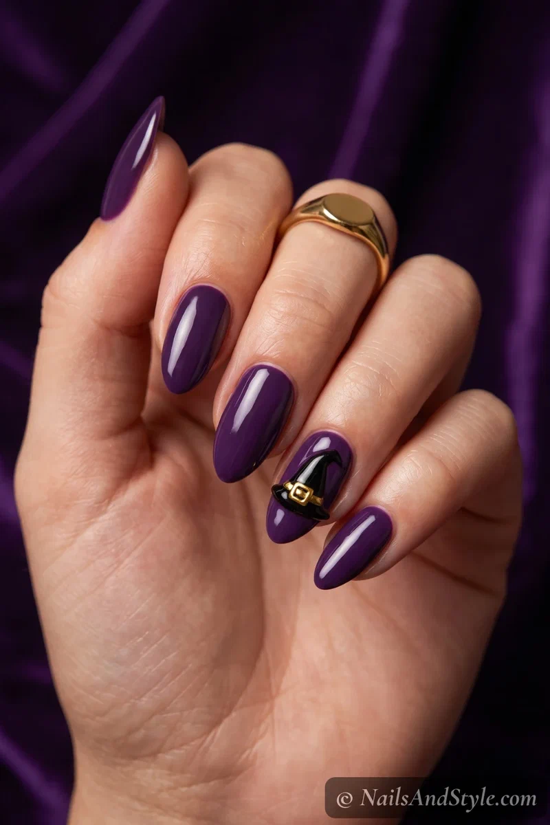 Deep purple nails with a black witch hat and gold buckle