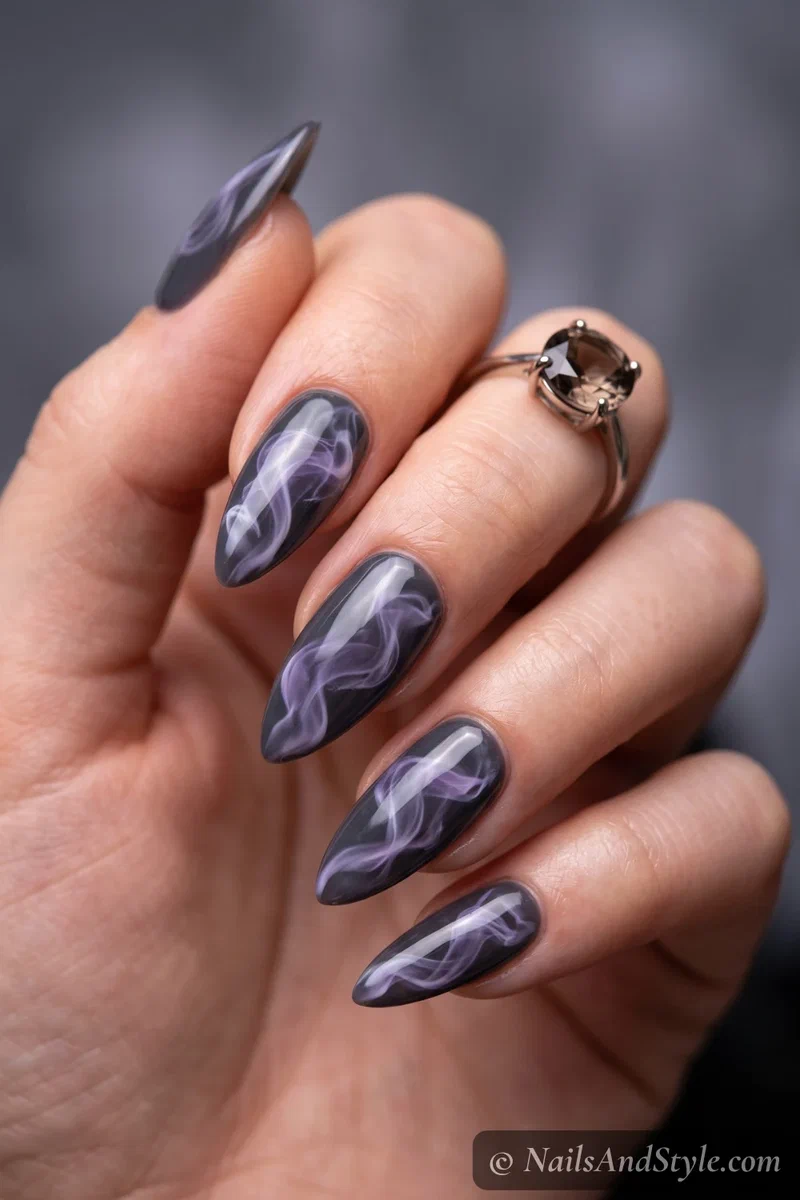 Dark grey nails with wisps of translucent white and purple magic smoke