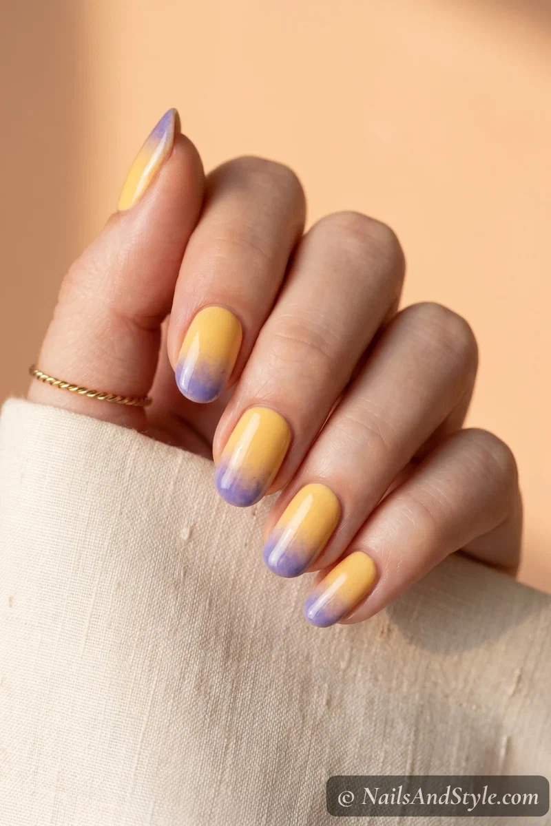 Yellow nails with blueberry purple gradient tips softly fading at the edges on medium round nails